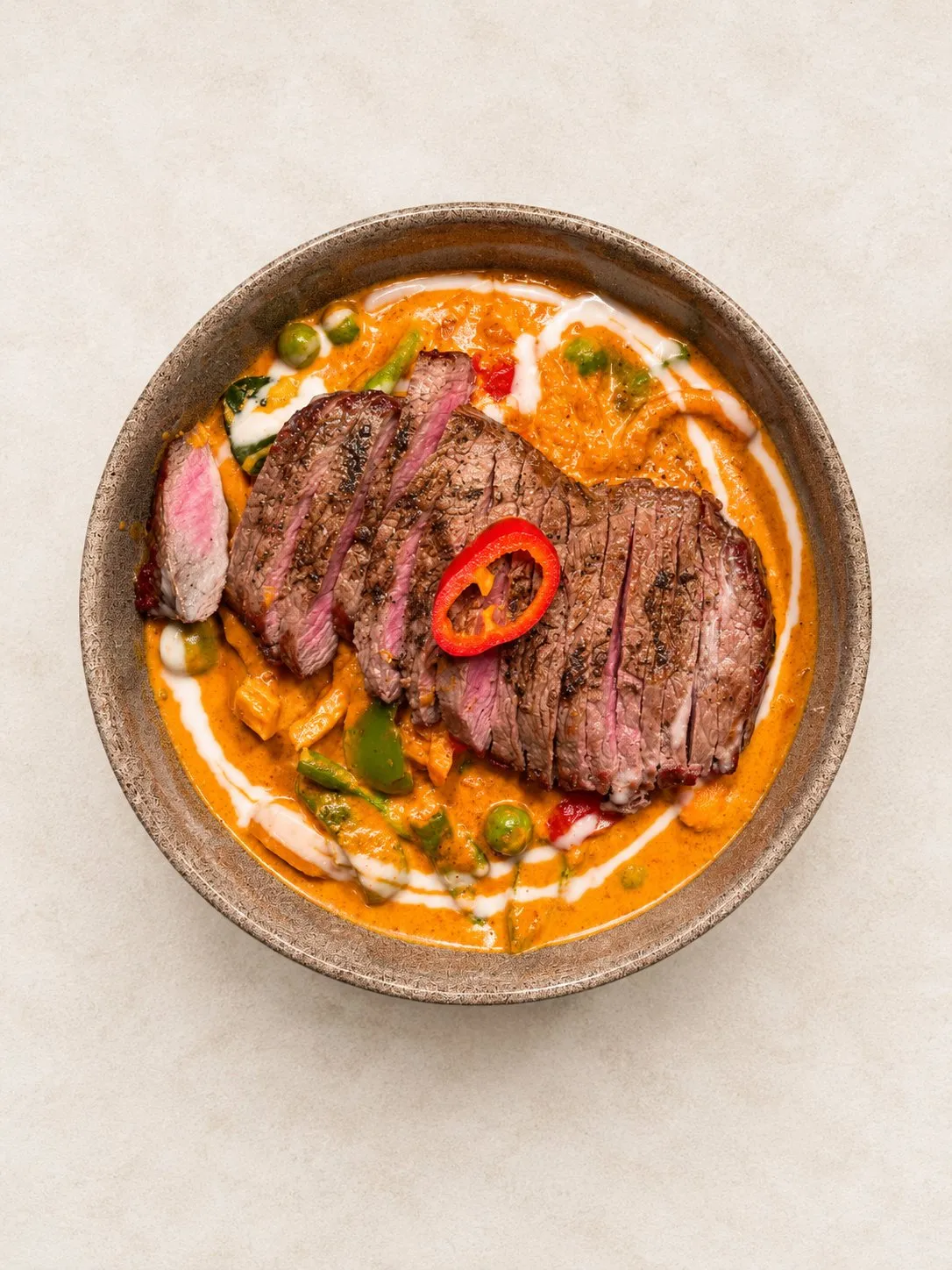 Gaeng Phet Entrecôte – Rotes Thai-Curry mit Entrecôte, Kokosmilch, Bambus und Thai-Basilikum.