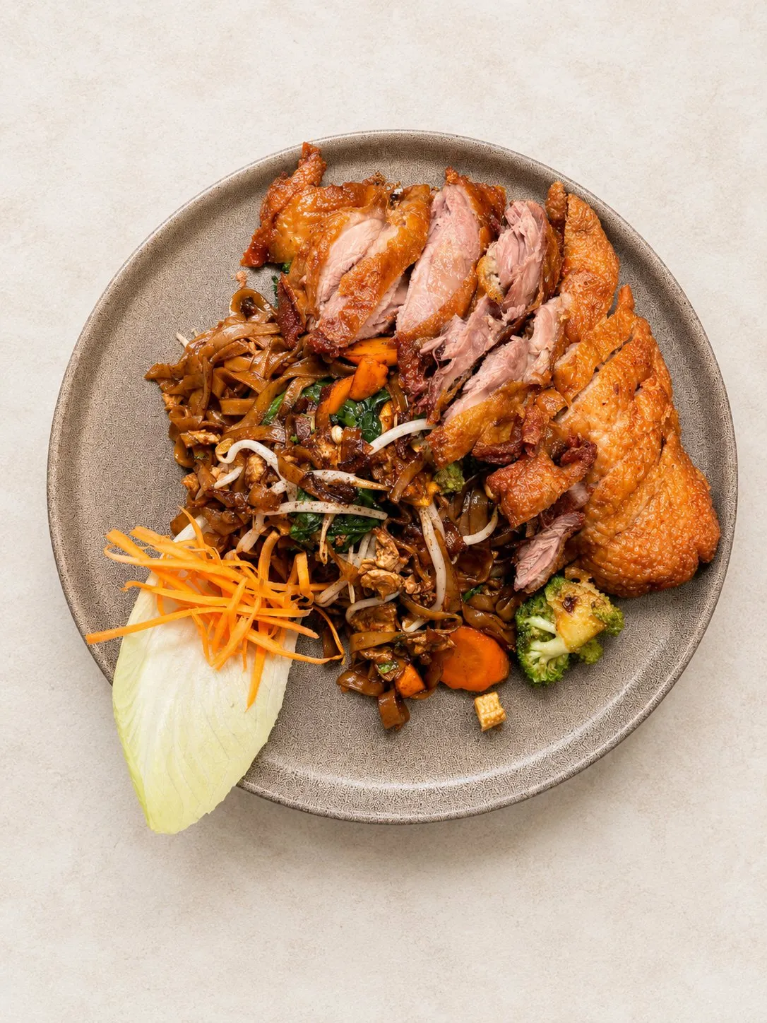 Pad Si Ew mit Entenfleisch – Breite Reisnudeln mit Ente, Ei und Gemüse in süßer Sojasauce.